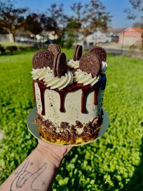 Cookies-and-cream cake with chocolate drips, sandwich cookies, and white frosting